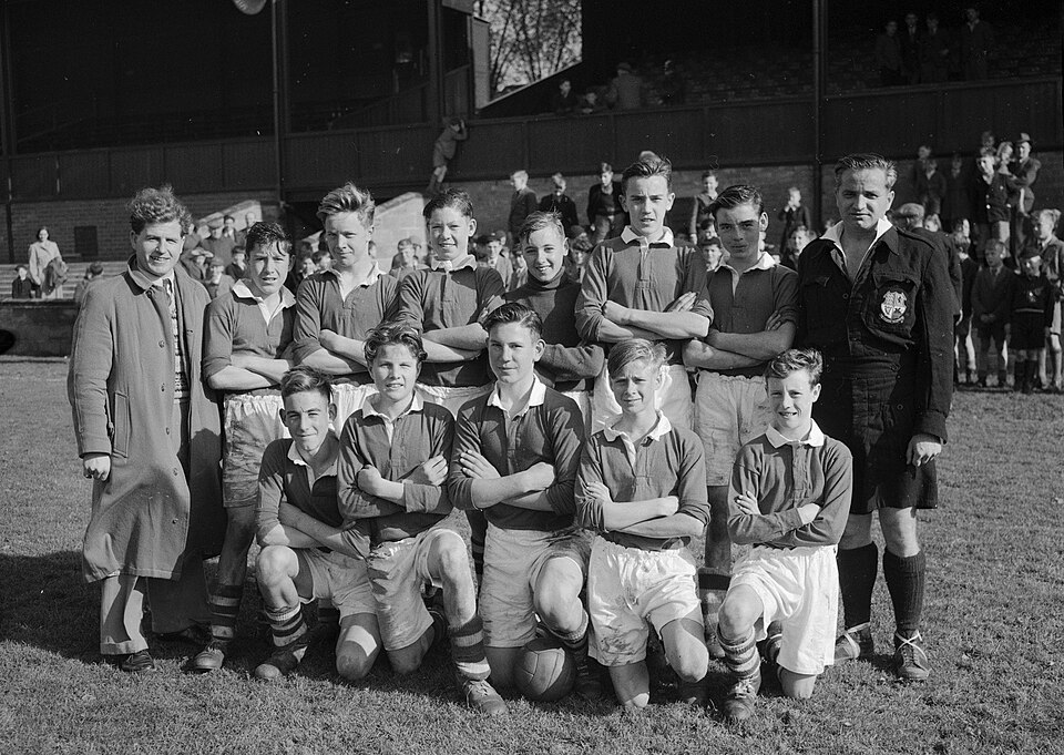 Hinchas viendo varios partidos de fútbol en una pantalla gigante