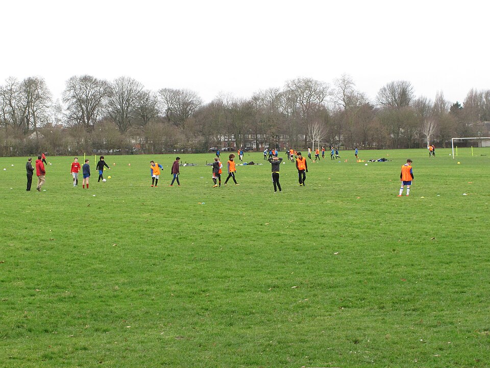 Vista aérea de un partido de fútbol con ambos equipos compactos